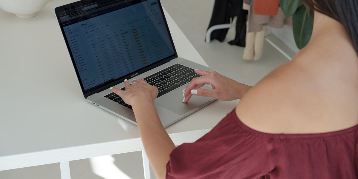 Commerçante vérifiant les informations de son établissement sur un ordinateur portable