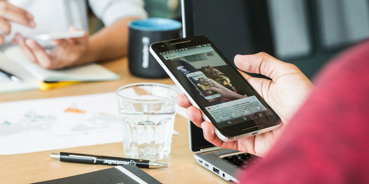 Professionnel vérifiant les avis de son établissement sur son smartphone